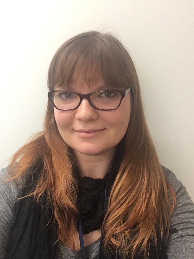 Photo of Kathryn Vanderboll, a white woman with long red hair and glasses.