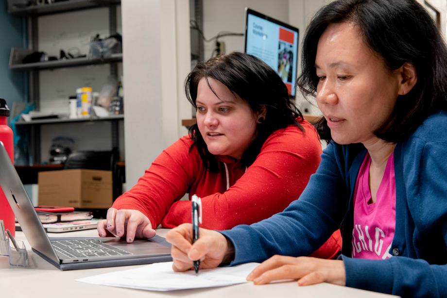 library staff helping a student a laptop in scholarspace